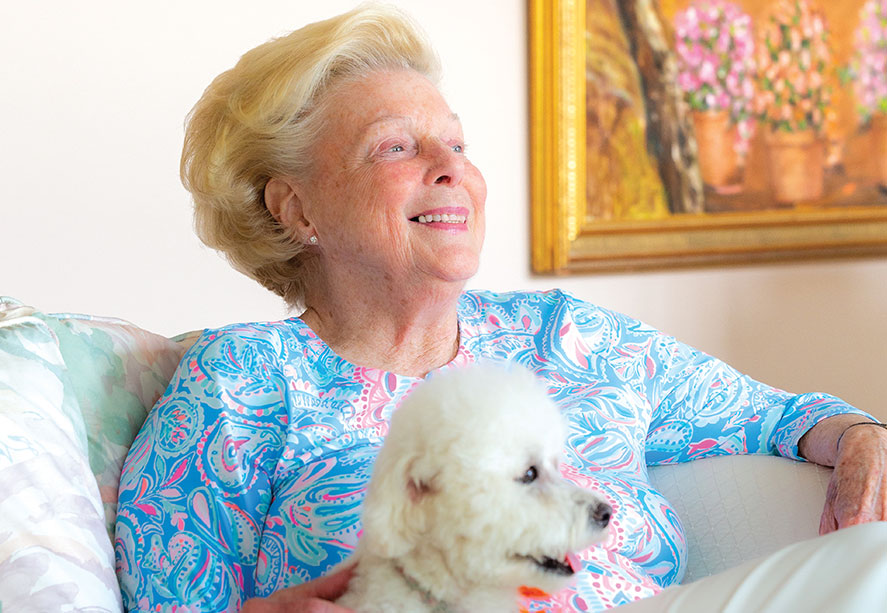 A woman sitting down with her dog.