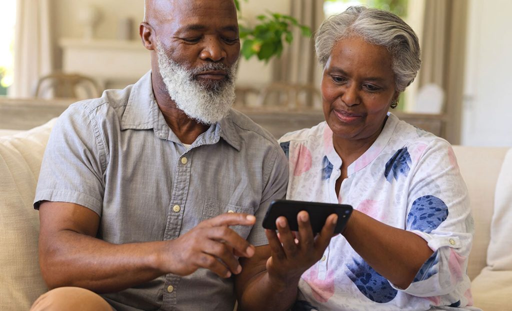 A couple looking at information on a mobile phone.
