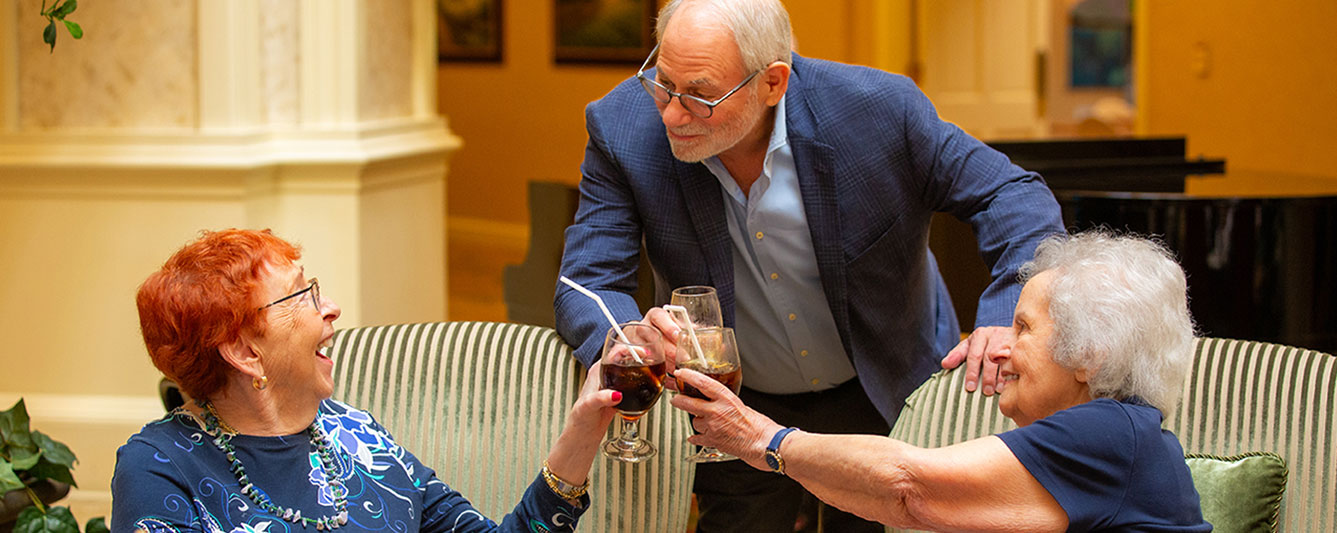 Three people clinking their glasses together in a toast.