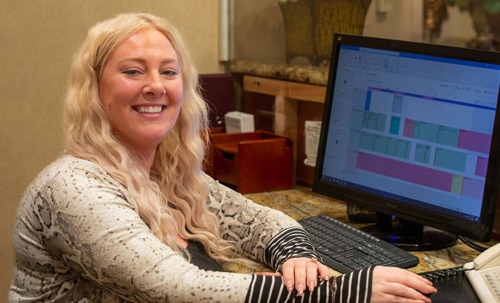 Alex Waters sitting at a desk with a computer.