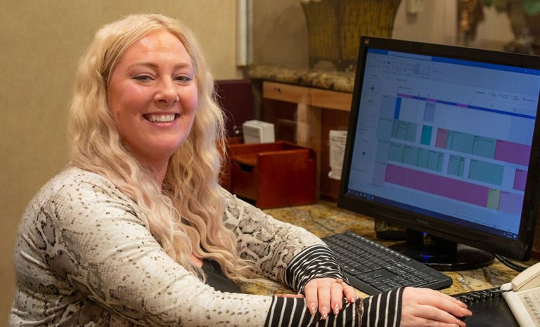Alex Waters sitting at a desk with a computer.