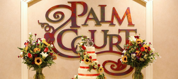 Palm Court sign with flowers and cake.